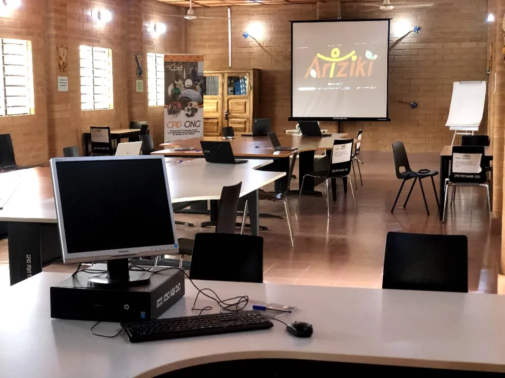 Salle de formation du centre ARIZIKI, à Tinré : tables de travail, ordinateurs et écran de projection.
